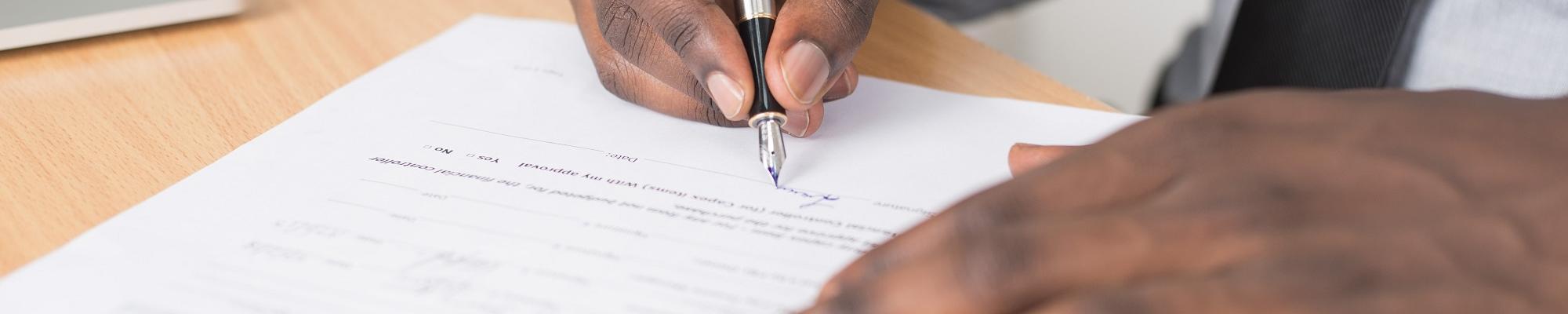 hands signing a form